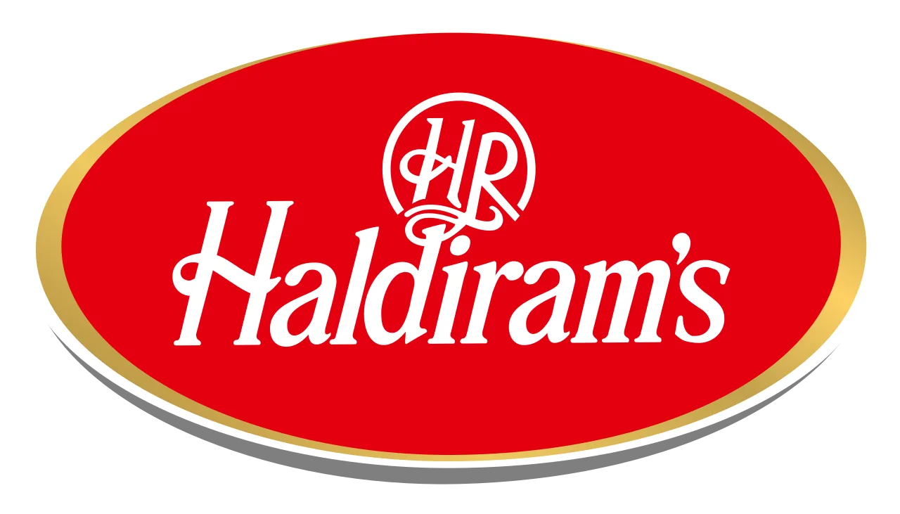 Haldiram's premium food brand logo featuring red oval design with gold border and white script text, representing a leading food supplier and manufacturer in the wholesale food industry.