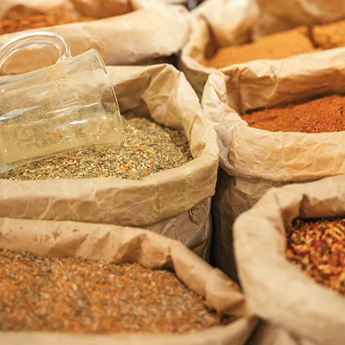 Vibrant assortment of spices in paper bags showcases fresh herbs and culinary diversity.